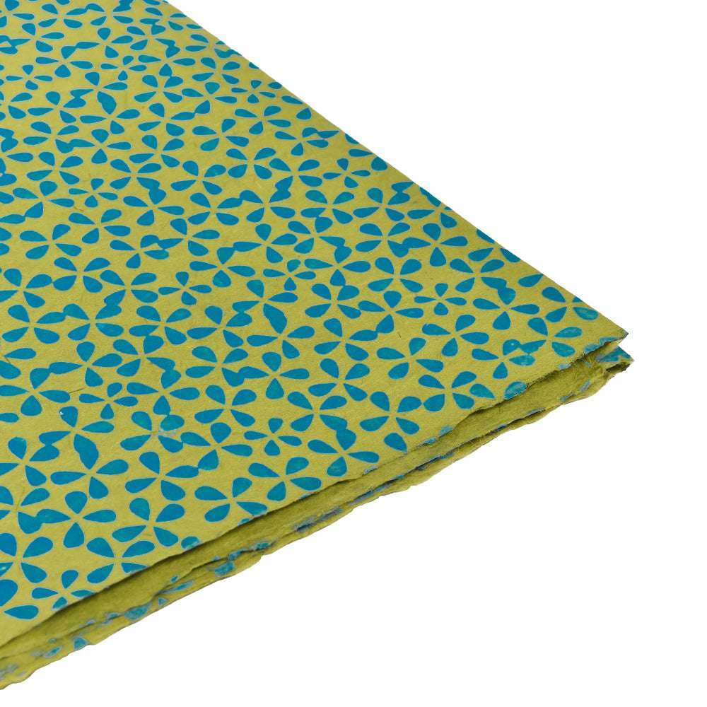 Ein gefalteter Bogen ☆ gelbes Nepalpapier mit einem sich wiederholenden blauen geometrischen Blumenmuster auf Weiß - perfekt für Buchbinden oder Geschenkverpackungen.