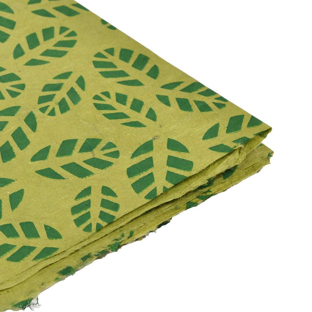 Ein Stapel ☆ handgefertigter Nepalpapierbögen in Maigrün, jeder verziert mit einem dunkelgrünen Blättermuster für einen natürlichen, handwerklichen Look.