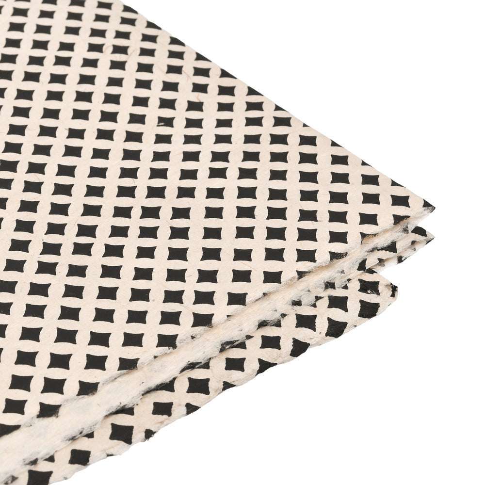 Stapel handgefertigter Nepalpapierbögen von ☆ mit einem schwarzen geometrischen Quadrat- und Rautenmuster - ideal für einzigartige Bucheinbände oder Geschenkverpackungen.