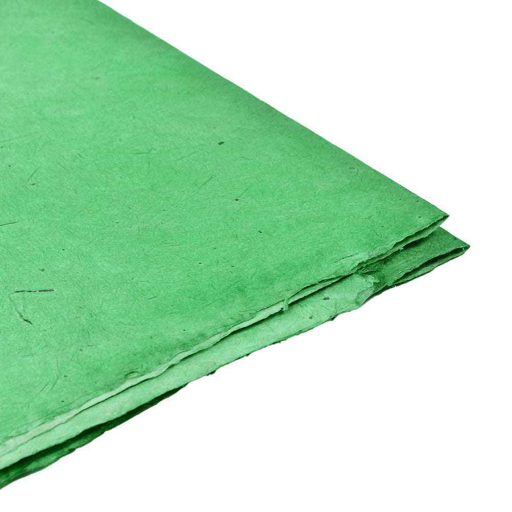 Stapel grüner handgefertigter Nepalpapierbögen von ☆ mit rauen Kanten, perfekt zum Buchbinden oder Verpacken von Geschenken, dargestellt auf weißem Hintergrund.