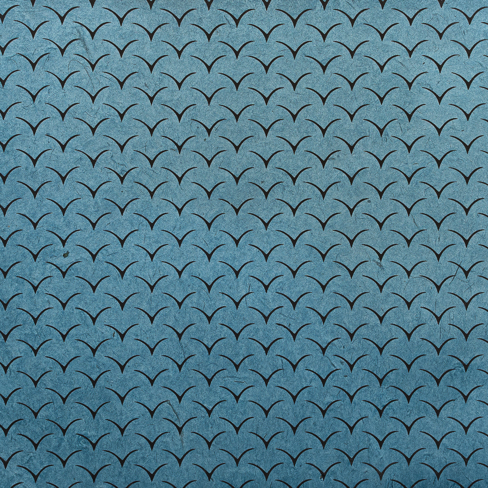 Blauer Hintergrund mit kleinen schwarzen, V-förmigen Linien in einem Raster – ideal als Geschenkpapier oder für Bastelarbeiten. Entscheiden Sie sich für nachhaltiges Papier wie Nepalpapier von ☆, wenn Sie eine umweltfreundliche Variante suchen.