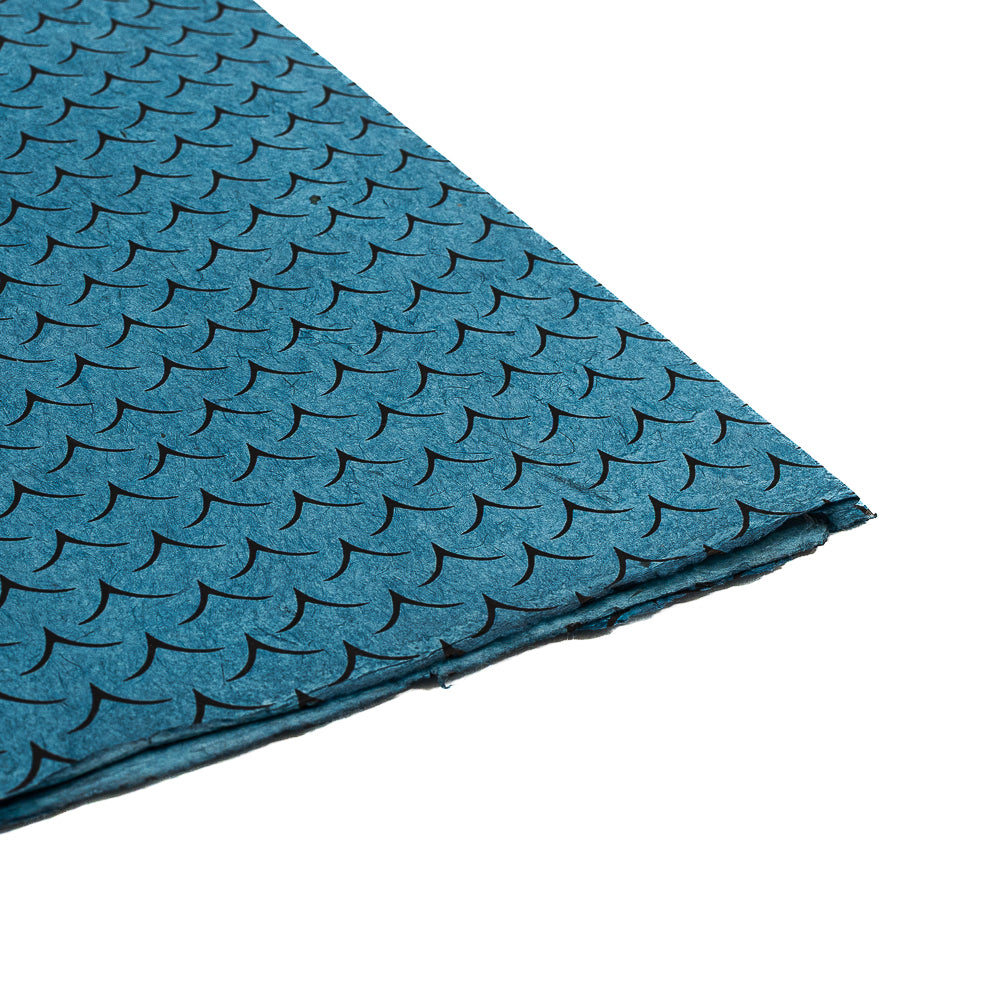 Ein Stapel blauer Nepalpapier-Bögen von ☆ mit einem sich wiederholenden schwarzen, wellenförmigen Muster auf weißem Hintergrund – das perfekte nachhaltige Papier für einzigartige Geschenkverpackungen.