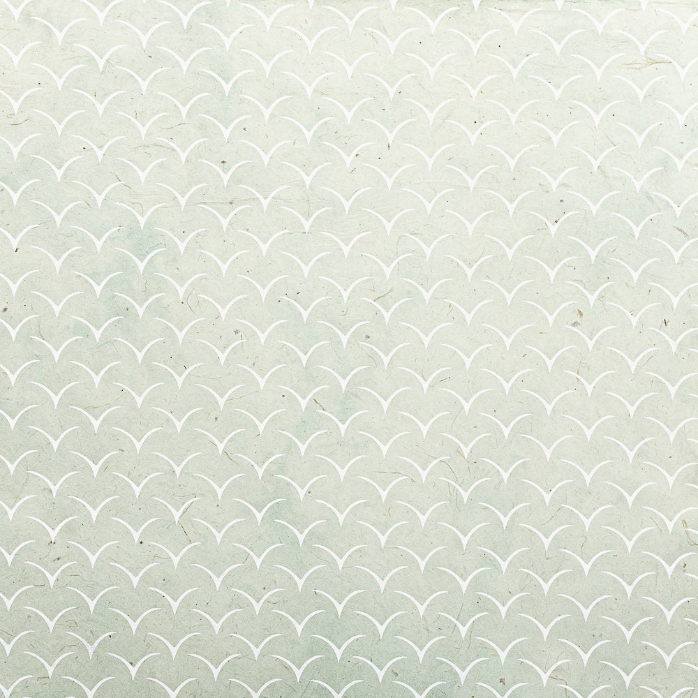 Hellgrüner Hintergrund mit einem Muster aus weißen, geschwungenen, V-förmigen Linien, die an Wellen oder Schuppen erinnern – hergestellt aus nachhaltigem Papier von ☆, ideal als Geschenkpapier.