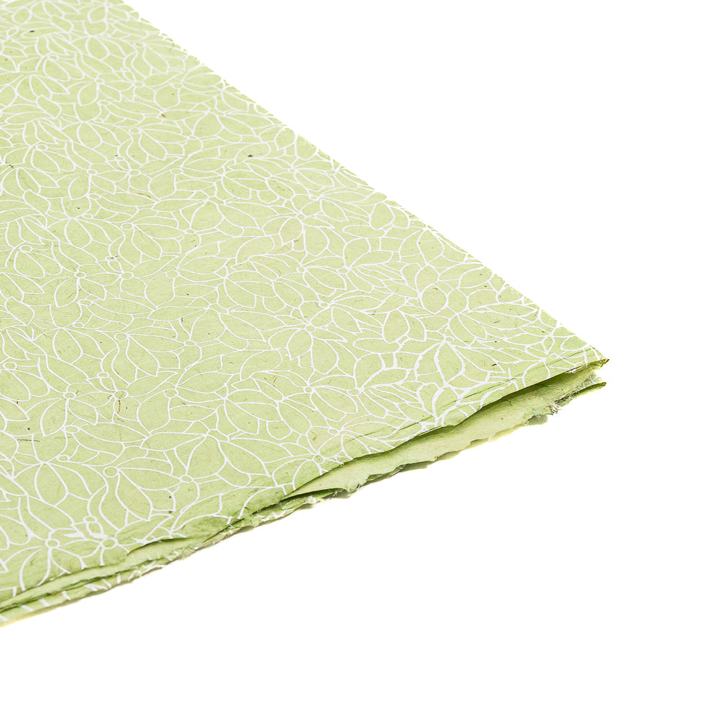 Gefalteter grüner Stoff mit weißem Blattmuster, abgebildet auf weißem Hintergrund. Dieses ☆-Design eignet sich ideal als Geschenkpapier oder für DIY-Projekte und lässt sich gut mit Nepalpapier und anderen nachhaltigen Papieralternativen kombinieren.