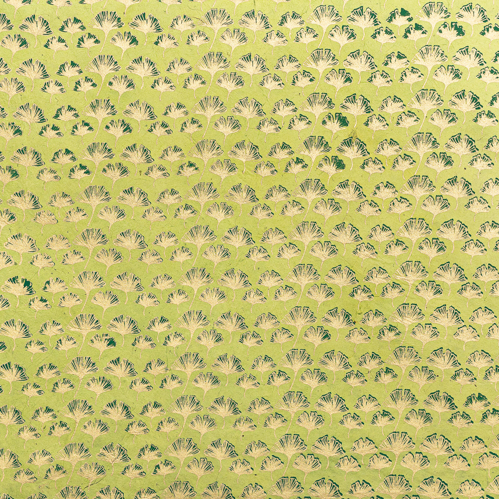 Das ☆-Markenzeichen zeigt grüne und beige fächerförmige Blätter auf hellgelbem Hintergrund, was ihm eine strukturierte Optik verleiht – ideal für Geschenkverpackungen mit Nepal-Papier oder anderen nachhaltigen Materialien.