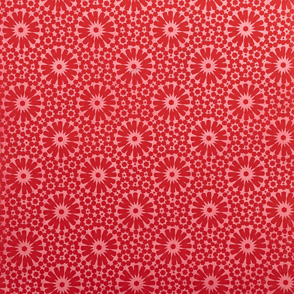 Rotes und rosa geometrisches Blumenmuster mit kreisförmigen Motiven auf einer glatten Oberfläche – ideal zum Verpacken von Geschenken oder zum Basteln mit nachhaltigem Nepalpapier von ☆.