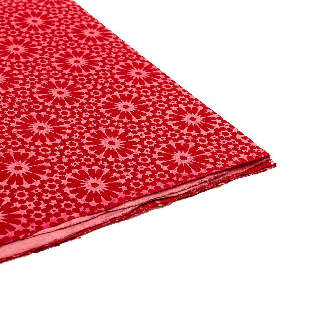 Ein Stapel ☆ roten Geschenkpapiers mit einem rosa Blumen- und geometrischen Muster, das von koreanischen Lotus-Motiven inspiriert ist und auf weißem Hintergrund abgebildet ist.