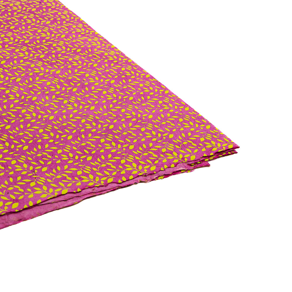 Farbenfrohes Nepalpapier von ☆ mit Muster, rosa mit gelben Blattmotiven auf weißem Hintergrund – ideal zum Verpacken von Geschenken und um mit nachhaltigem Papier einen stilvollen Akzent zu setzen.