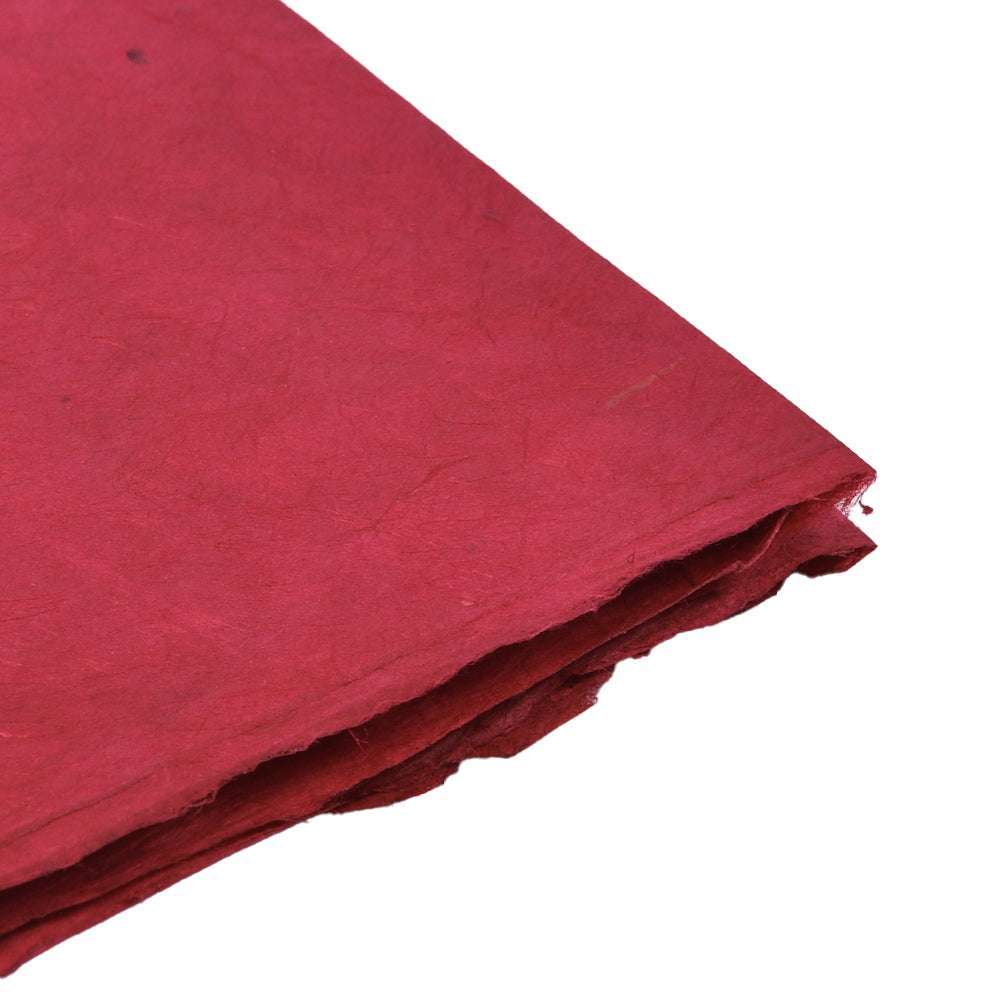 Stapel ☆ strukturierter roter handgefertigter Nepalpapierbögen in einem Winkel auf weißem Hintergrund - ideal für Geschenkverpackungen oder Buchbindearbeiten.