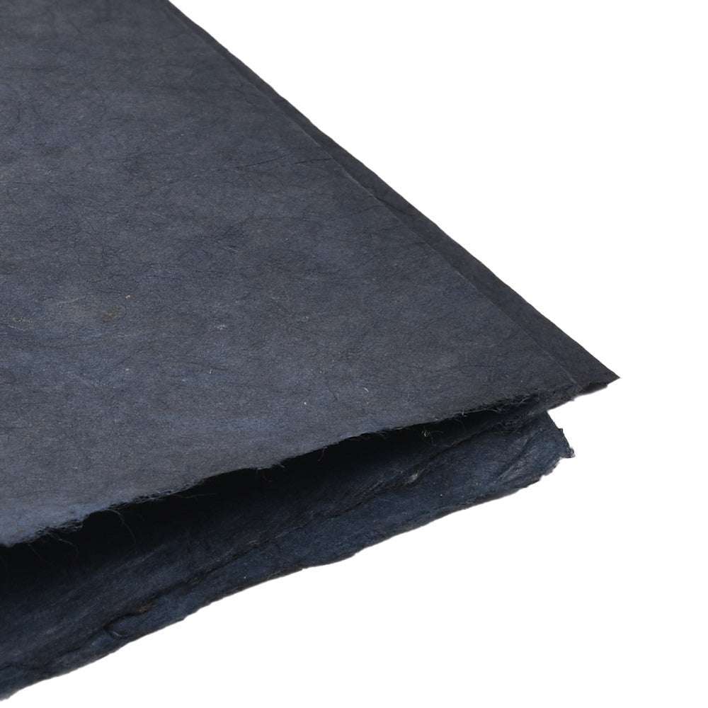 Zwei Blätter strukturiertes, dunkelblaues Nepalpapier von ☆ überlappen sich auf weißem Hintergrund - ideal für Buchbinden oder elegante Geschenkverpackungen.