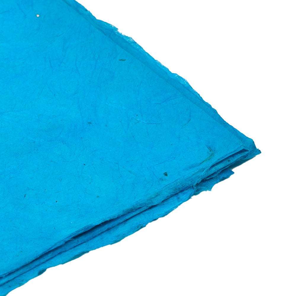 Nahaufnahme eines gefalteten, strukturierten blauen handgeschöpften Papiers von ☆ auf weißem Hintergrund - ideal für eine einzigartige Geschenkverpackung.