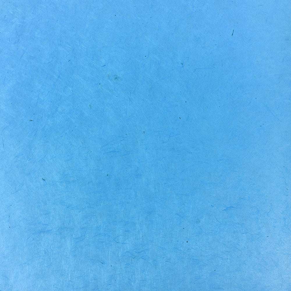 Hellblaue strukturierte Oberfläche mit dezenten Kratzern und schwachen Markierungen von ☆, perfekt für Geschenke Verpacken oder Buchbinden mit feinem Nepalpapier.