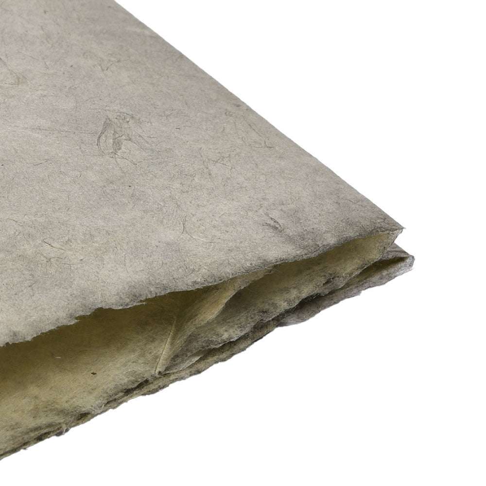 Eine Nahaufnahme von ☆s rauem, strukturiertem Nepalpapier mit unebenen Rändern, perfekt für Buchbinden oder das Einwickeln einzigartiger Geschenke.