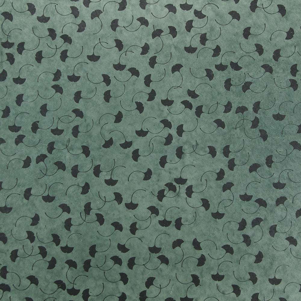 ☆ Nepalpapier in Grün mit wiederholtem Muster aus kleinen schwarzen Ginkgo-Blättern und feinen Wirbellinien - ideal zum Buchbinden oder als Geschenkverpackung.