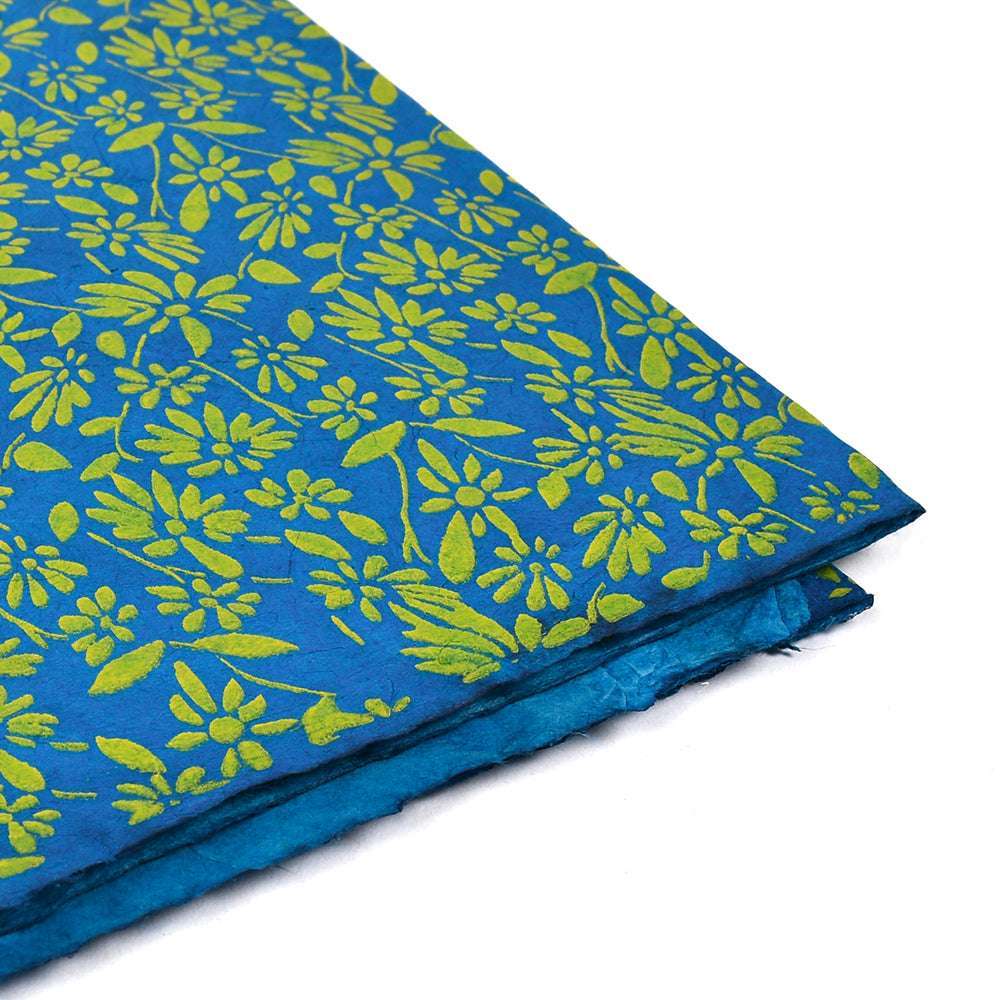 ☆ Blaues Nepalpapier mit gelben Blumenmustern, ideal zum Verpacken von Geschenken oder zum Buchbinden, an der Ecke gefaltet auf weißem Hintergrund.