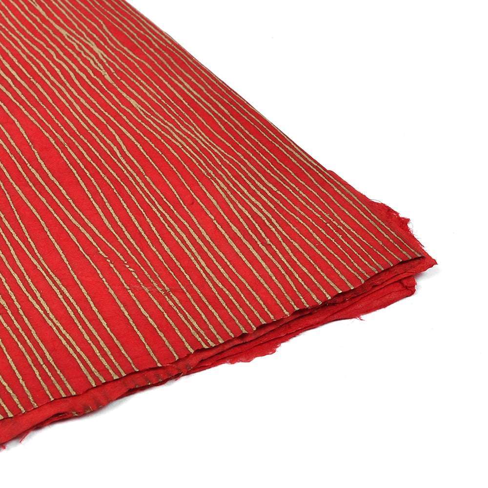 ☆ Nepalpapier in Rot mit goldenen Streifen, gefaltet an der Ecke auf weißem Hintergrund - perfekt zum Verpacken von Geschenken oder für die Buchbindung.
