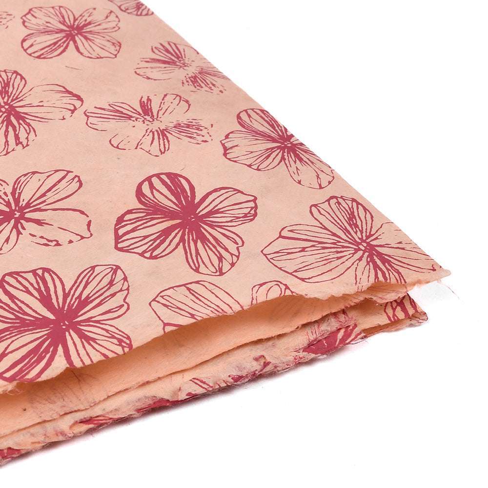 Nepalpapier mit rosa Blumenmuster und roter Umrandung, ideal zum Verpacken von Geschenken oder zum Buchbinden, gestapelt auf weißem Hintergrund.