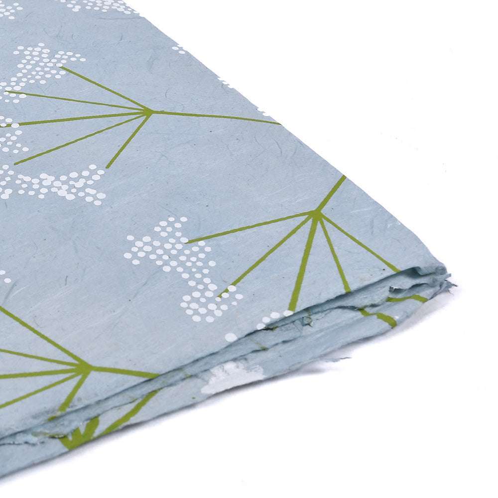 Gefaltetes blaues Nepalpapier von ☆ mit grün-weißem Blumenmuster und zarten Zweig- und Punktmustern. Dieser handgefertigte Schachtelhalm Blau verleiht jedem kreativen Projekt eine einzigartige Note.