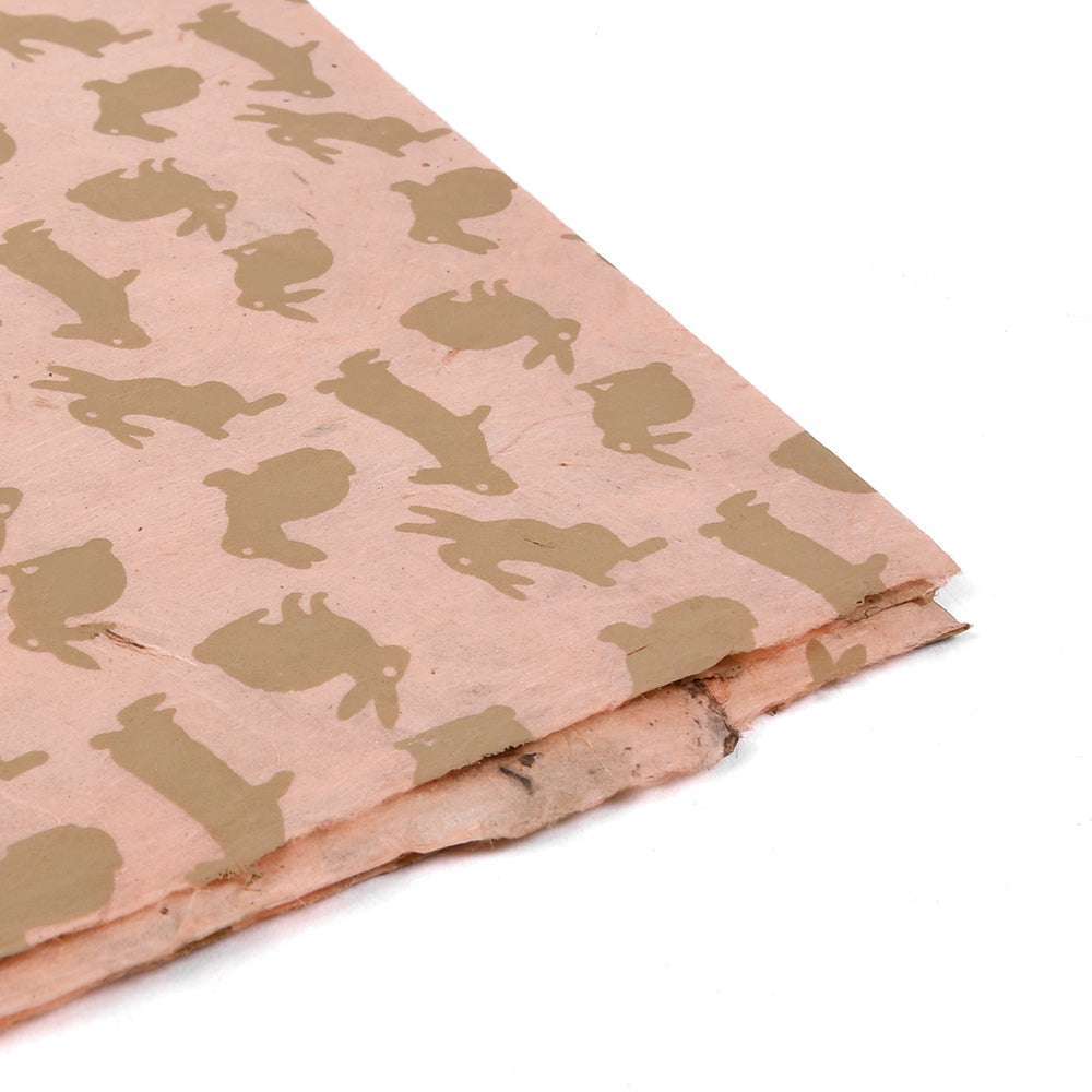 Ein rosa Blatt ☆ handgeschöpftes Nepalpapier mit braunen Kaninchensilhouetten - eine einzigartige und charmante Wahl für Geschenkverpackungen.