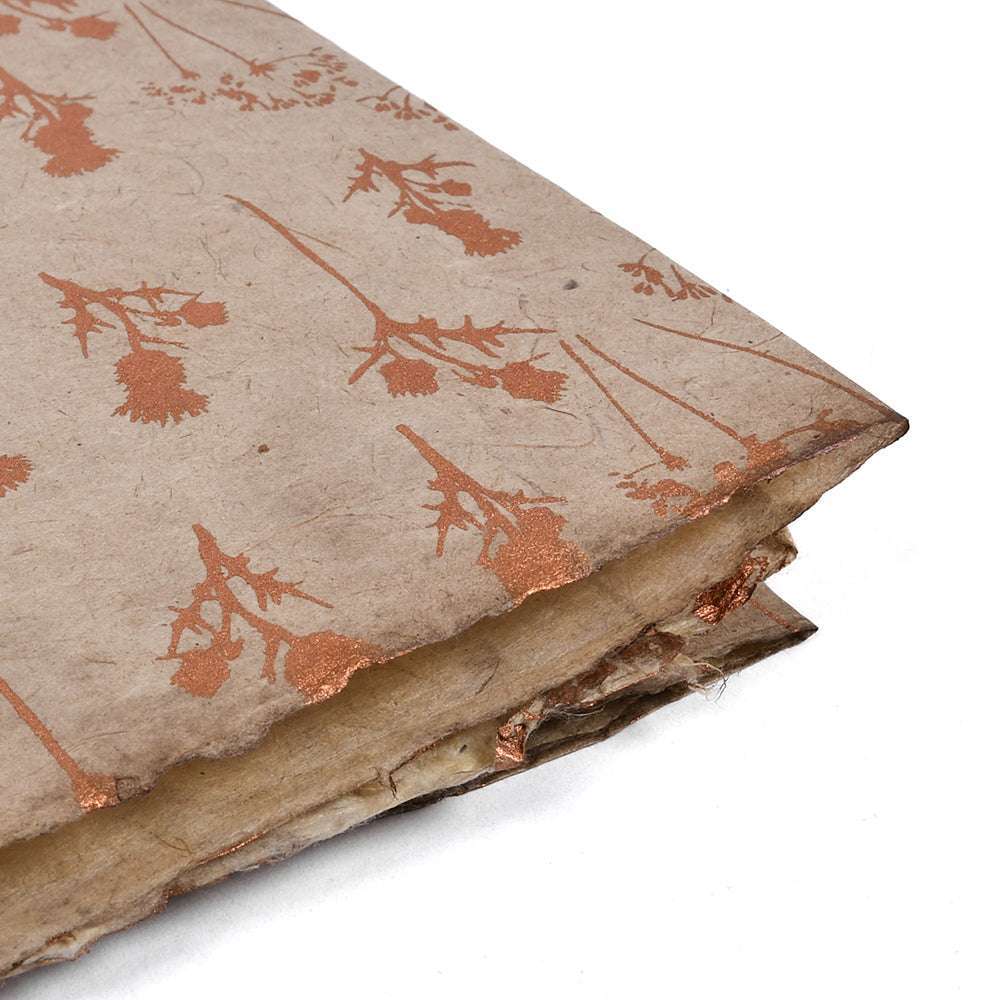 Eine Nahaufnahme eines alten, abgenutzten Buches mit einem braunen, blumengemusterten Nepalpapiereinband und ausgefransten Seiten - ein bezauberndes ☆ Stück für Buchbinden oder kreative Geschenke verpacken.