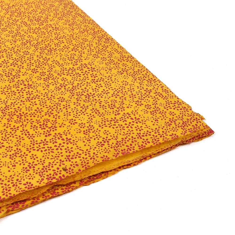 ☆ Nepalpapier in Gelb mit kleinen roten Punkten, sorgfältig gefaltet auf weißem Hintergrund-ideal zum Buchbinden oder Geschenke verpacken.