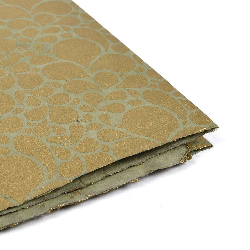 ☆ goldenes und grünes handgefertigtes Nepalpapier mit einzigartigem kreisförmigem Muster, schräg dargestellt - ideal zum Buchbinden oder stilvollen Verpacken von Geschenken.