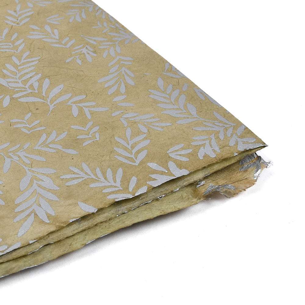 Ein Stapel ☆ braunes handgefertigtes Nepalpapier mit Blattsilbermustern und rauen Kanten - ideal zum Einpacken von Geschenken oder zum Buchbinden.