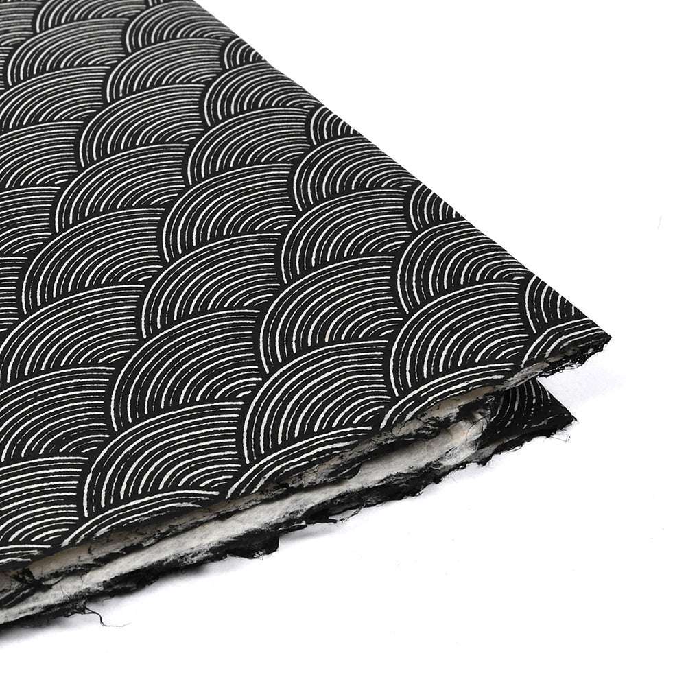 Die schwarzen und weißen Nepalpapierbögen zeichnen sich durch sich wiederholende halbkreisförmige Wellenmuster und raue Kanten aus - ideal zum Buchbinden oder als einzigartige Geschenkverpackung.