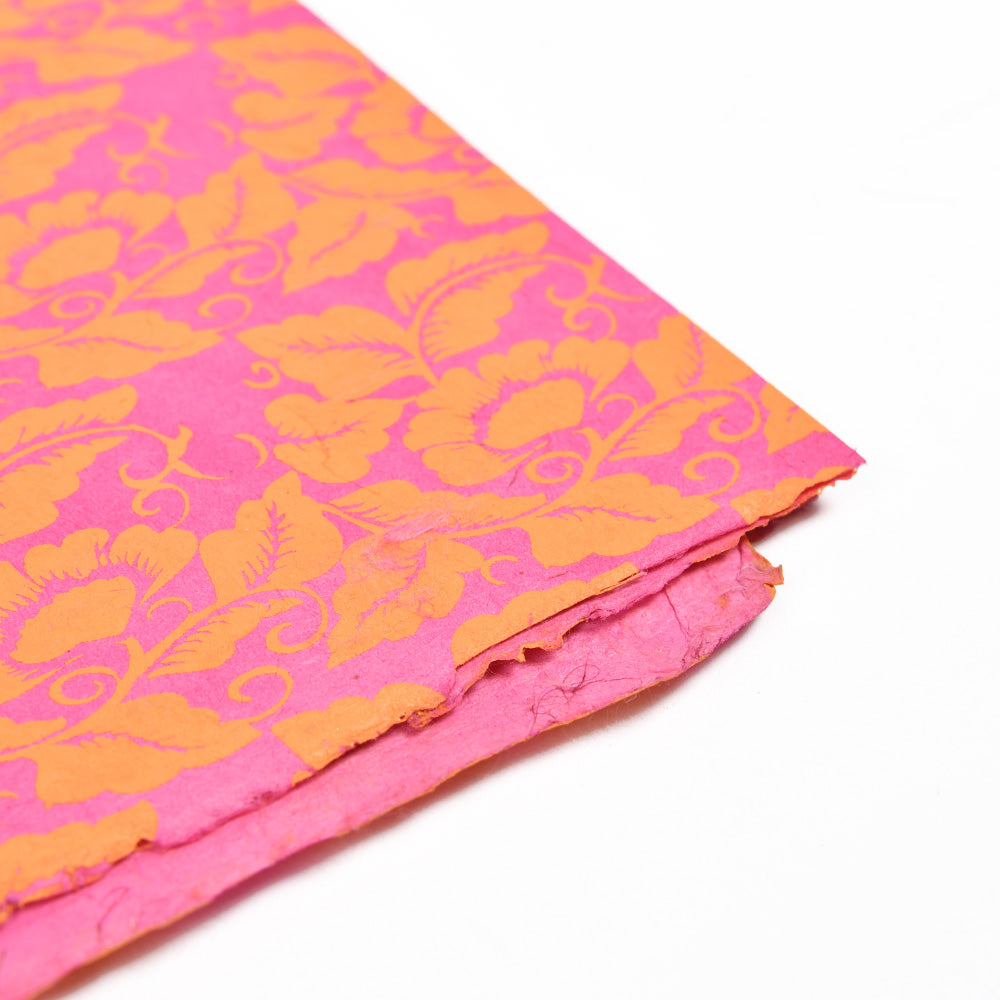 ☆ rosa und orangefarbenes Nepalpapier mit Blumenmuster, ideal zum Verpacken von Geschenken oder zum Buchbinden, abgebildet mit einer gefalteten Ecke auf weißem Hintergrund.