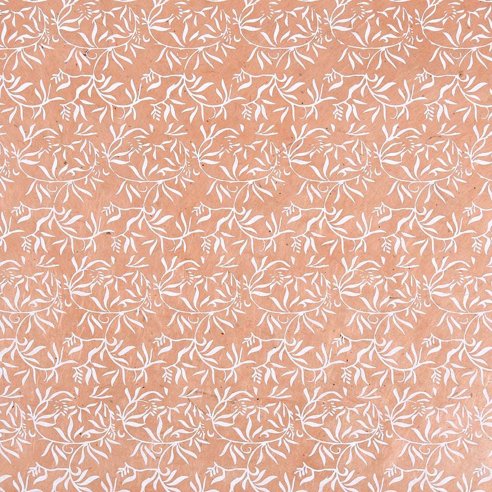 Ein weißes florales Rankenmuster wiederholt sich symmetrisch auf einem pfirsichfarbenen Hintergrund - ideal für Geschenke Verpacken oder Buchbinden mit ☆ Nepalpapieren.