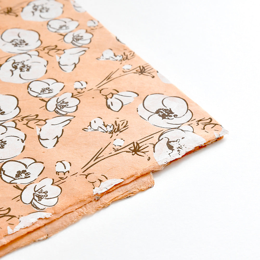 Pfirsichfarbenes Nepalpapier von ☆ mit schwarzem und weißem Blumenmuster, perfekt für Buchbinden oder Geschenke Verpacken, ordentlich gestapelt auf einer weißen Fläche.