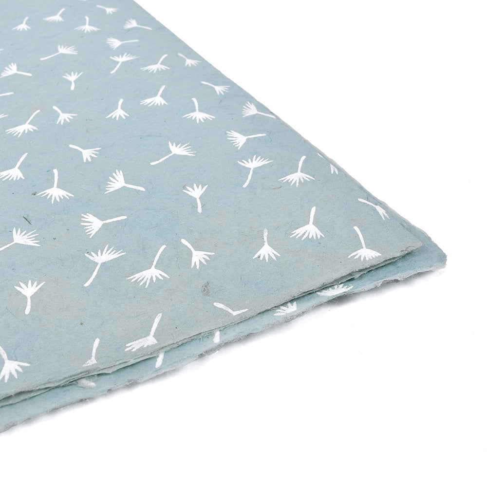 ☆ hellblaues Nepalpapier mit weißem Löwenzahnsamen-Aufdruck, ideal für Buchbinden oder Geschenkverpackungen, abgebildet an der Ecke gefaltet auf weißem Hintergrund.