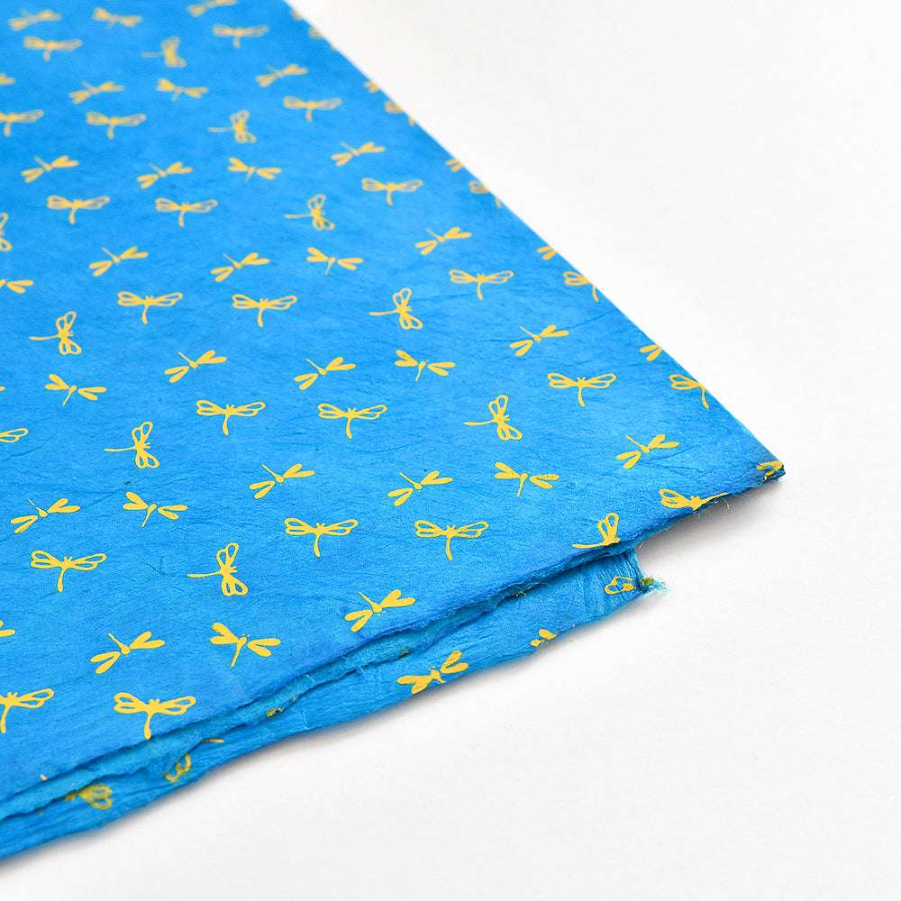 ☆ blaues Seidenpapier mit einem sich wiederholenden Muster aus kleinen gelben Schleifen, ideal für Geschenke Verpacken oder Buchbinden, abgebildet auf weißem Hintergrund.