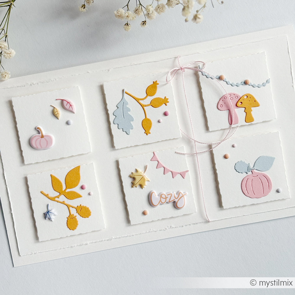 Handgefertigte Karte mit sechs Quadraten, die jeweils mit Papierausschnitten zum Thema Herbst und dem Wort „cosy“ verziert sind; mit Puffy-Sticker-Akzenten für zusätzliche Tiefe – perfekt für kreative Projekte.