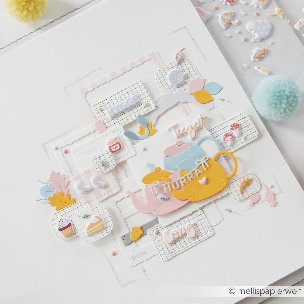 Scrapbook-Seite mit Teekanne, Tassen, Keksen und Dekorationen im Gemütlichkeits-Stil in Pastellfarben auf weißem Hintergrund – perfekt für kreative Projekte oder als Ergänzung für dein Bullet Journal. Puffy-Sticker-Verzierungen unterstreichen die charmante, verspielte Atmosphäre.
