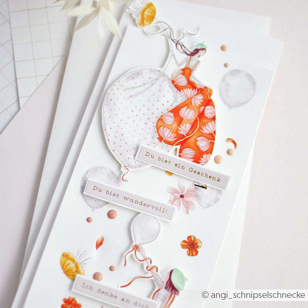 Handgefertigte Karte von Alexandra Renke mit Luftballons, einem Mädchen in einem orangefarbenen Kleid und deutschem Text auf Weiß - ideal für Bastelprojekte Motive mit Rub-On Figurenwelt und Transferfolien Basteln.