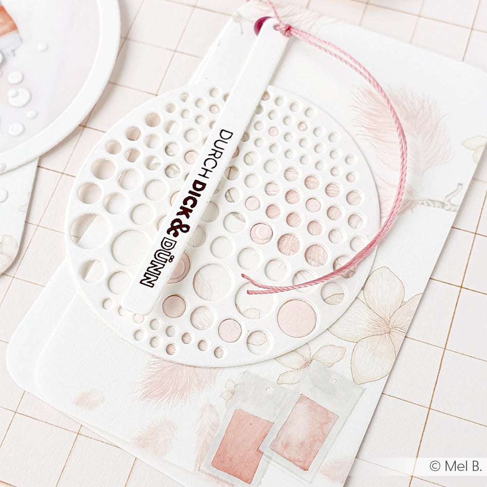 Weiße Karte mit rosafarbenen Motiven, versehen mit einem runden Anhänger mit Lochmuster und rosafarbener Kordel; mit dem Text DURCH DICK & DÜNN. Von Alexandra Renke. Perfekt für Transferfolien Basteln oder einzigartige Rub-On Motive in personalisierten Bastelarbeiten.