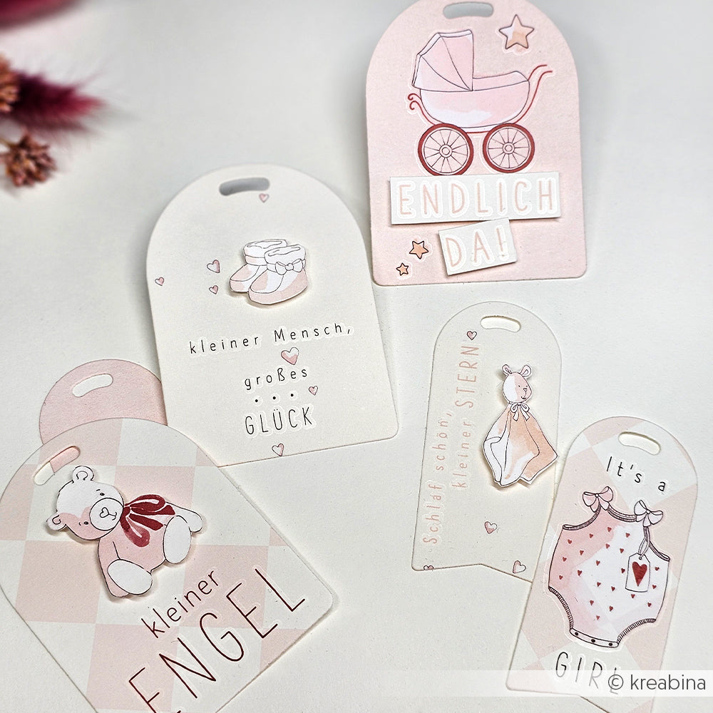 Fünf pastellrosa und weiße Geschenkanhänger zum Thema Baby von Alexandra Renke mit deutschem Text und niedlichen Illustrationen wie einem Kinderwagen und einem Teddybär - perfekt für Bastelprojekte Motive oder zum Personalisieren mit Transferfolien Basteln.