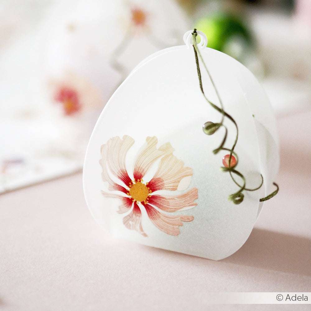 Transluzente weiße Schachtel mit einem rosa Blumen- und grünem Rankenmotiv von Alexandra Renke auf einer zartrosa Oberfläche - ideal für Transferfolien Basteln oder um Rub-On Florale Weihnachtsgrüße zu Ihren internationalen Weihnachtsmotiven hinzuzufügen.