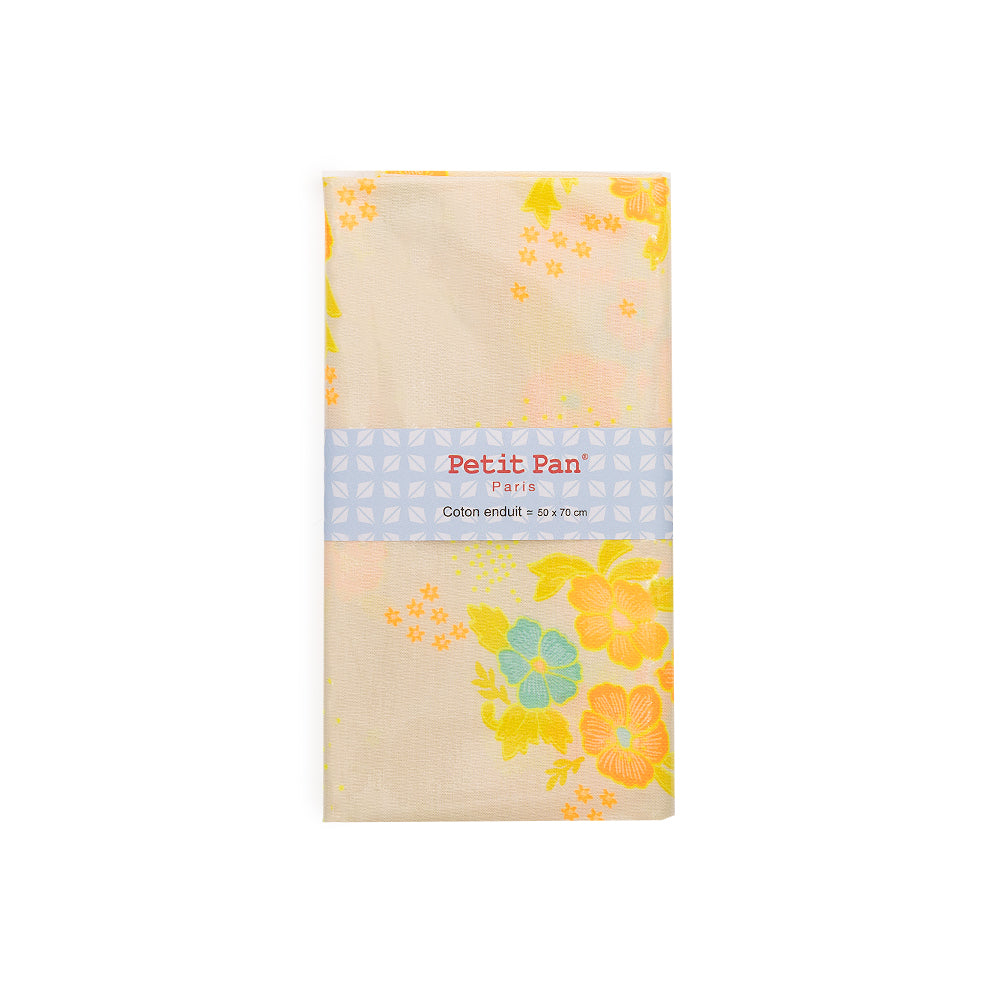 Gefalteter Baumwollstoff mit gelben und blauen Blumen, verpackt in einem Etikett mit der Aufschrift „Petit Pan Paris“. Dieser beschichtete Stoff ist wasserabweisend und eignet sich daher sowohl stilvoll als auch praktisch für eine Vielzahl von Nähprojekten.
