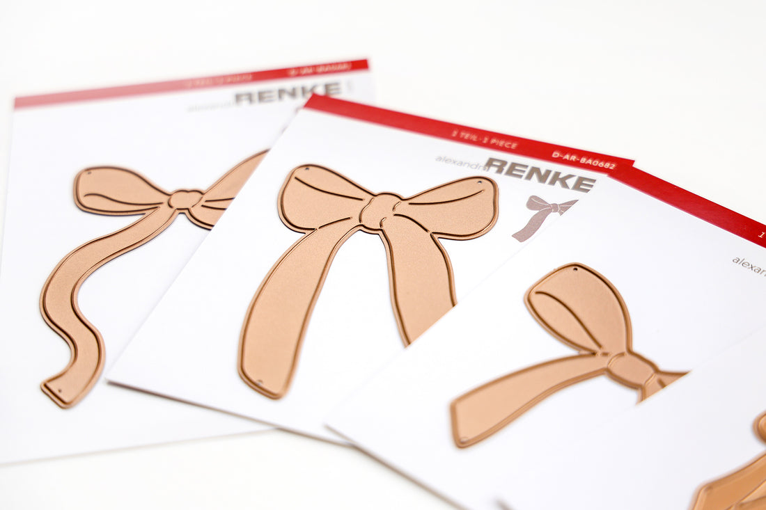 Drei Stanzformen in Form von Metallbögen auf weißen Karten mit roten Etiketten.