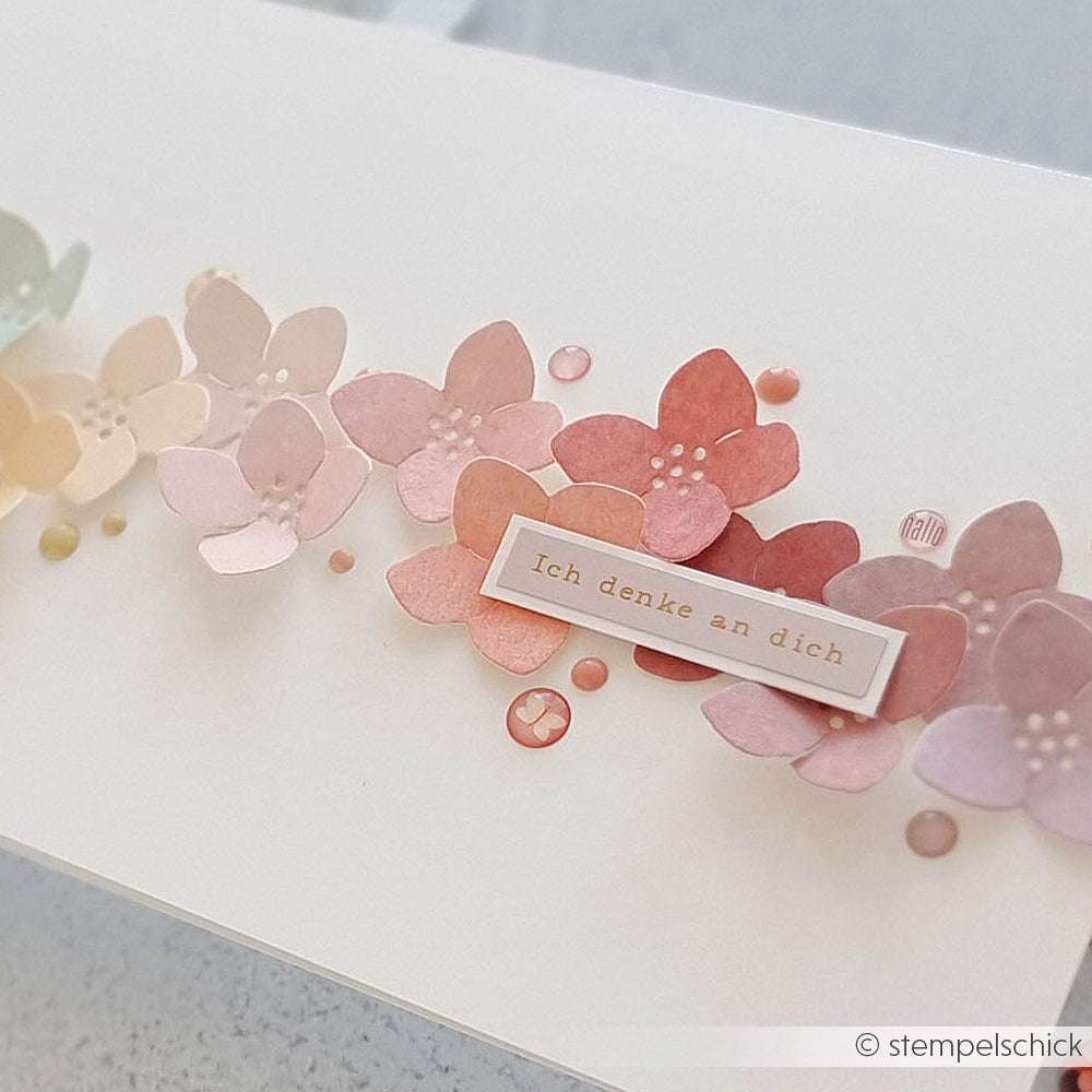 Pastellfarbene Papierblumen und Sticker Dots von Alexandra Renke mit einem deutschen "Ich denke an dich"-Aufkleber auf einer weißen Karte - ideal für kreative Kartengestaltung.