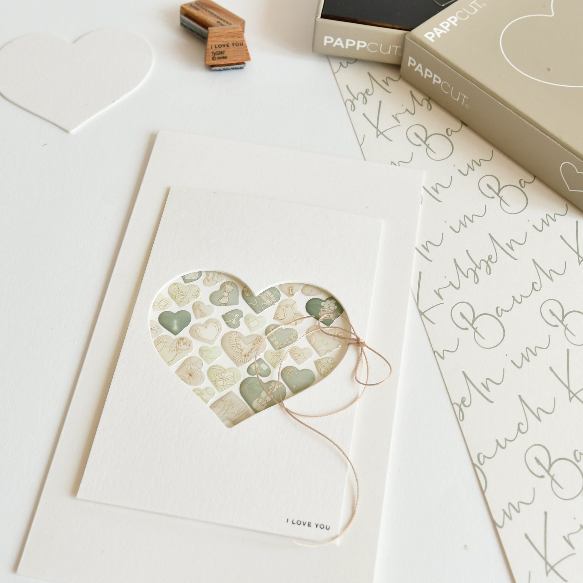Eine handgefertigte Karte von Alexandra Renke mit einem Herzausschnitt, Stickerherzen und einer "Ich liebe dich"-Nachricht am unteren Rand - perfekt für kreative Kartengestaltung.