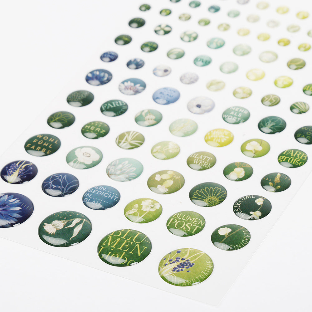 Ein Bogen Alexandra Renke runde Sticker Dots Blumenpost mit grünen und blauen Blumenmustern und deutschen Sprüchen - perfekt, um Ihren Buchbindearbeiten eine charmante Note zu verleihen.