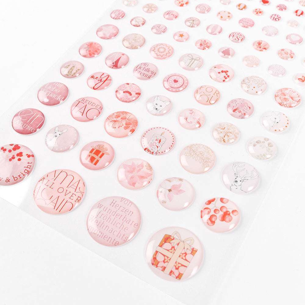 Ein Bogen runder rosa Sticker Dots von Alexandra Renke mit weihnachtlichen Motiven - ideal zum Kartenbasteln oder um Ihren Projekten einen Hauch von Rosa Schneegestöber zu verleihen.