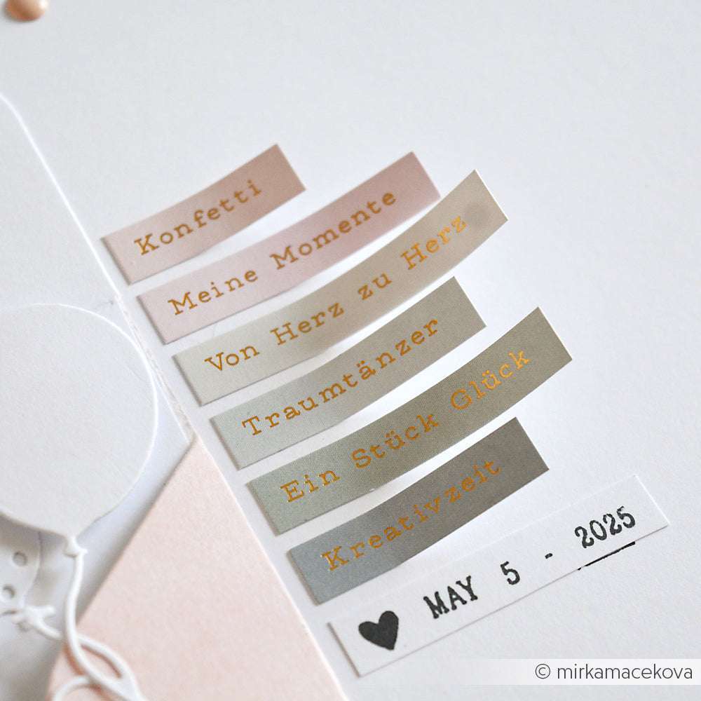 Sechs pastellfarbene Papieretiketten von Alexandra Renke für Kartengestaltung, jedes mit deutschen Worten und einem Datumsstempel "MAI 5 - 2025", angeordnet auf einer weißen Fläche.
