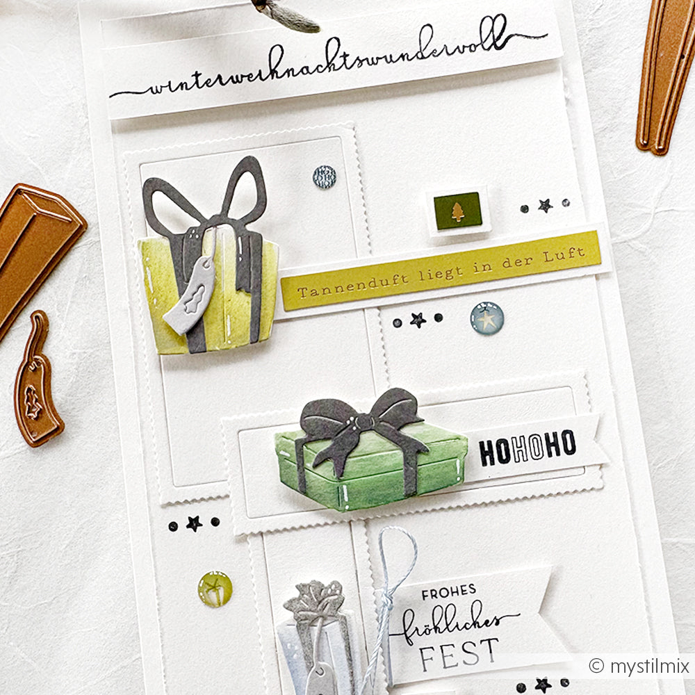 Handgemachte Weihnachtskarte von Alexandra Renke mit Geschenkillustrationen, festlichem Text und dekorativen Verzierungen wie Kartengestaltung und Sticker Streifen auf weißem Hintergrund.