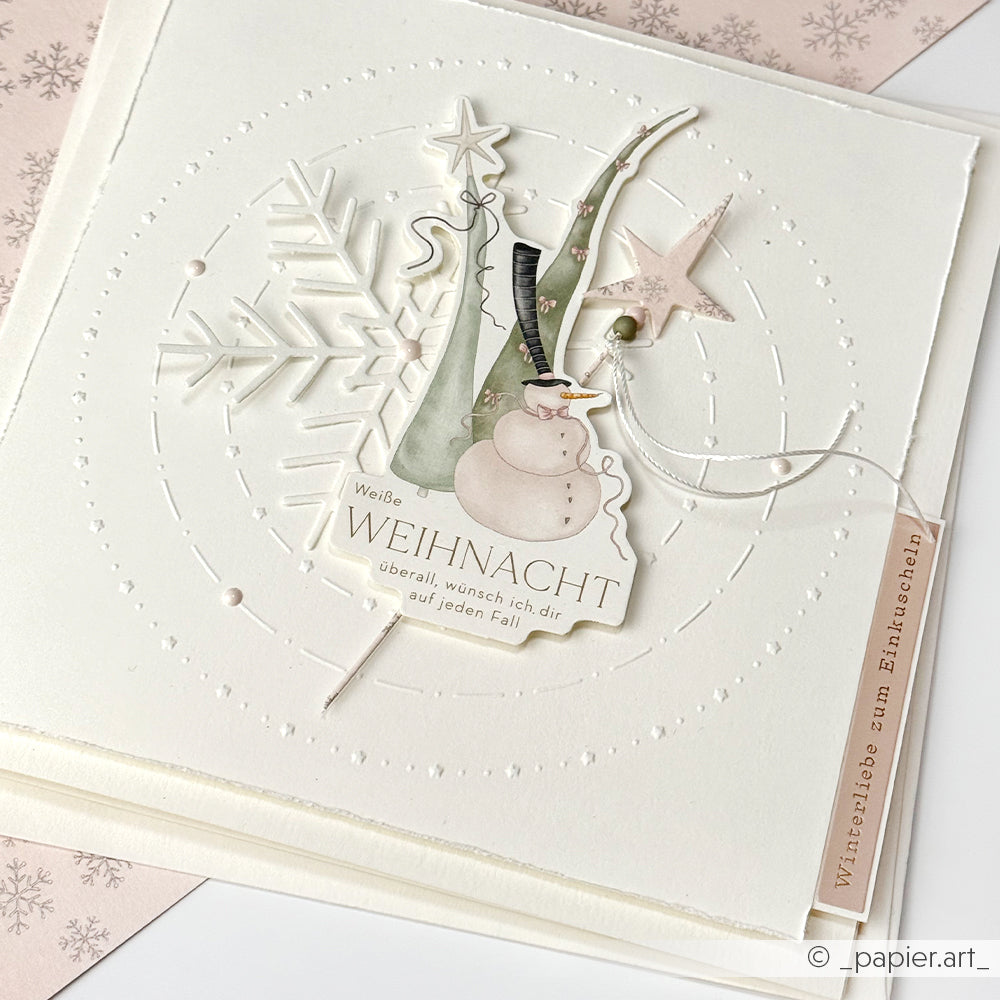 Handgemachte Weihnachtskarte von Alexandra Renke mit Schneemann, Stern, Schneeflocke und Weihnachtswünschen auf weißem Strukturpapier - ideal für Winter-Kuschelzeit und kreative Kartengestaltung.