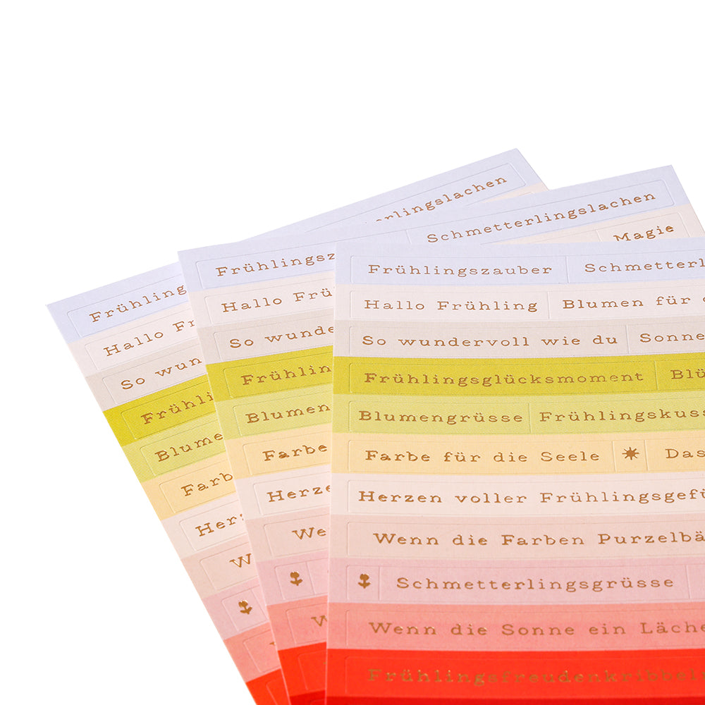 Alexandra Renke Sticker-Streifen: farbenfrohe Blätter mit deutschen Sprüchen in goldener Schrift, perfekt für die Kartengestaltung, aufgefächert angeordnet.