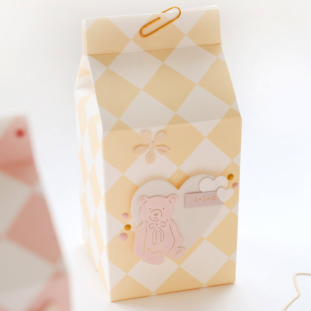 Gelb-weiß karierte Milchkarton-Geschenkbox von Alexandra Renke mit Teddybär-Dekoration und Büroklammer auf dem Deckel, ideal zum Basteln von Karten oder zum Verzieren mit Aufkleberstreifen.
